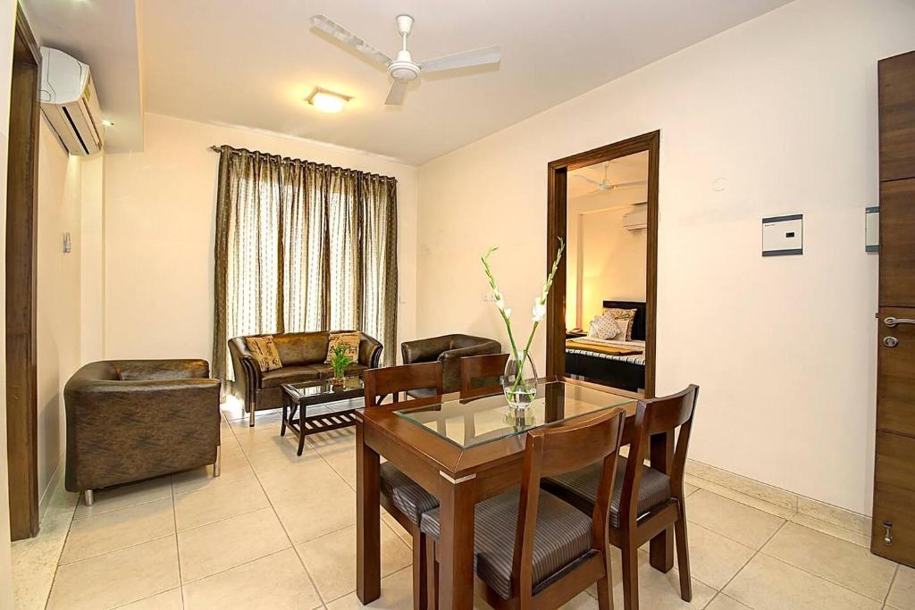 a living room with a table and a chair at Perch Service Apartment- Sector 40 in Gurgaon