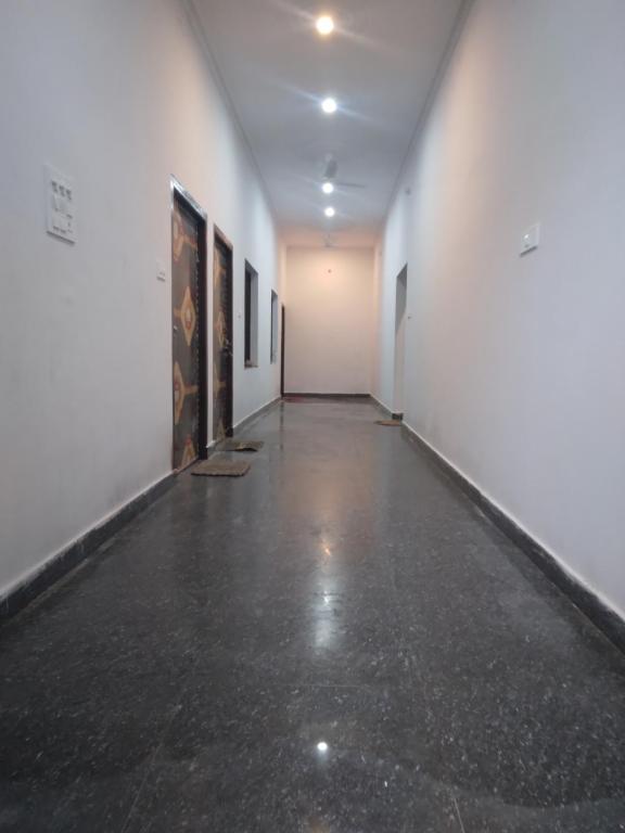 un couloir vide orné de peintures sur les murs dans l'établissement Happy Homestay, à Khajurâho