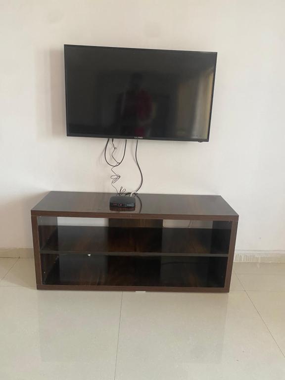 a flat screen tv sitting on top of a entertainment center at Delightful Dwellings 2bhk at 16th floor@kharadi in Pune
