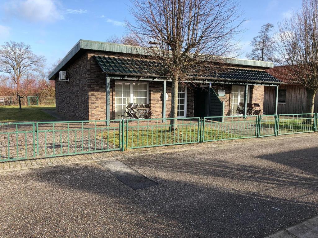 a brick house with a fence in front of it at Haus-Koralle-Wohnung-links in Boltenhagen