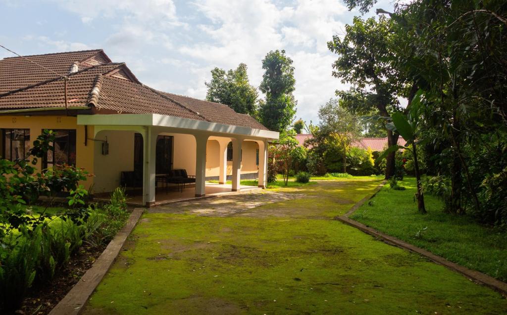 a house with a grass yard in front of it at The House of Black and White in Arusha