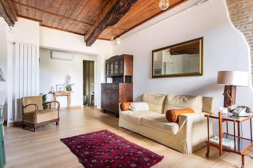 ein Wohnzimmer mit einem Sofa und einem Spiegel in der Unterkunft Adelaide al Borgo. in Castelnuovo di Porto