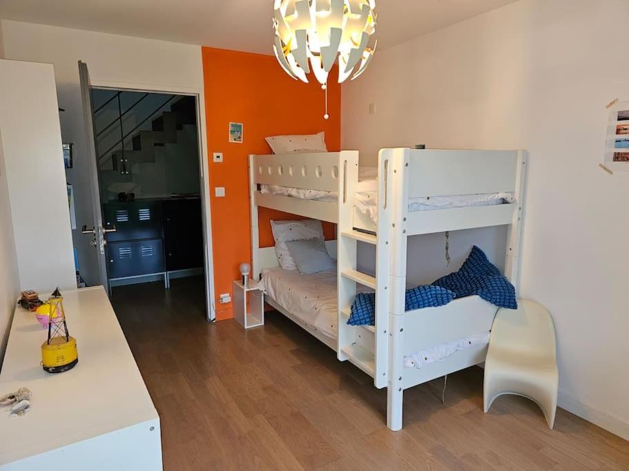 Zimmer mit 2 Etagenbetten und einer orangefarbenen Wand in der Unterkunft Villa vue Imprenable Aber Benoît in Saint-Pabu