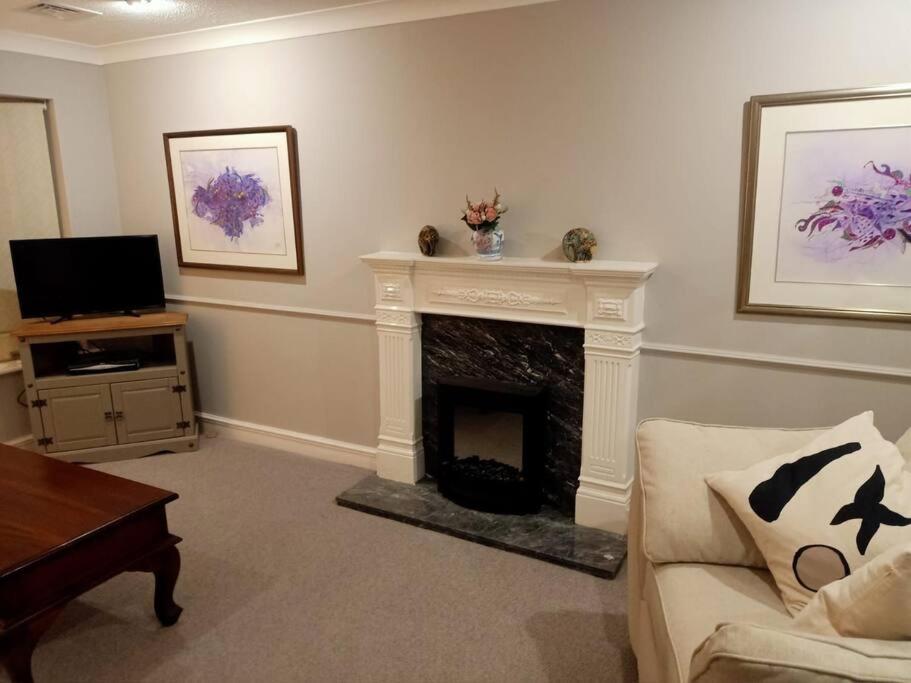 a living room with a fireplace and a tv at Lotus House in Needingworth
