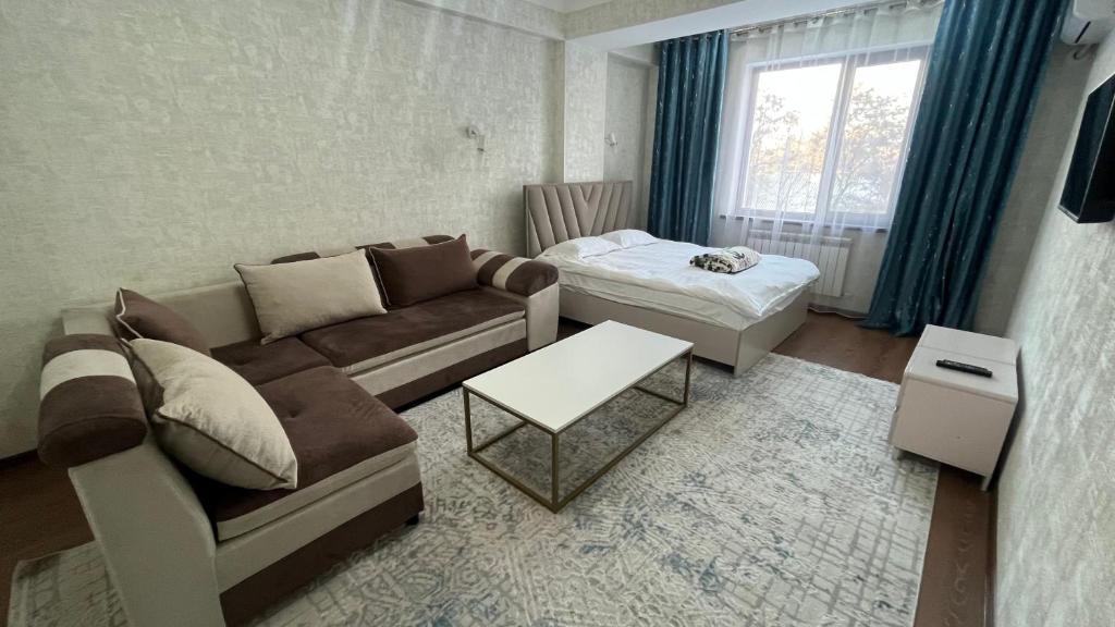 a living room with a couch and a table at Apartament Manasa in Bishkek