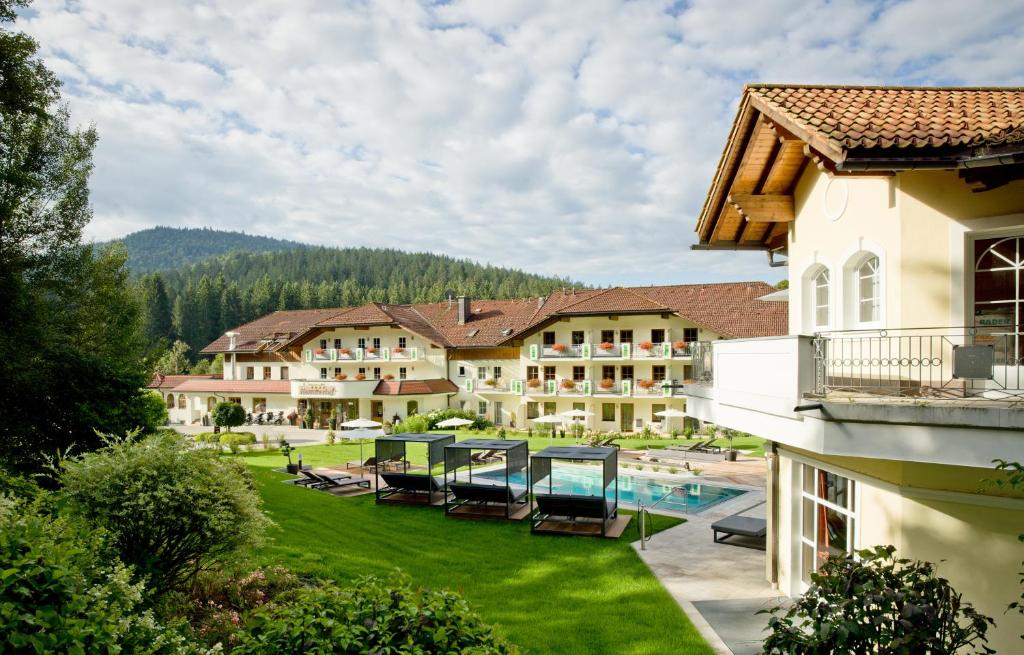 - une vue sur un complexe avec une cour et une piscine dans l'établissement Aktiv- und Wohlfühlhotel Hammerhof, à Bodenmais