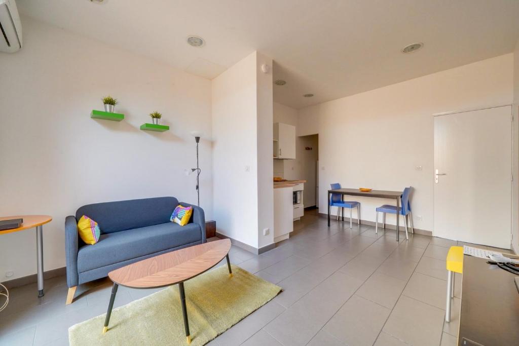 a living room with a blue couch and a table at Jolie petite maison de ville Bordeaux in Bordeaux