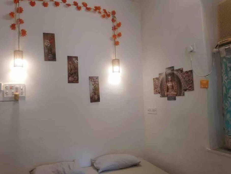 a room with a bed with pictures on the wall at A rustic earthy home A1 in Mumbai