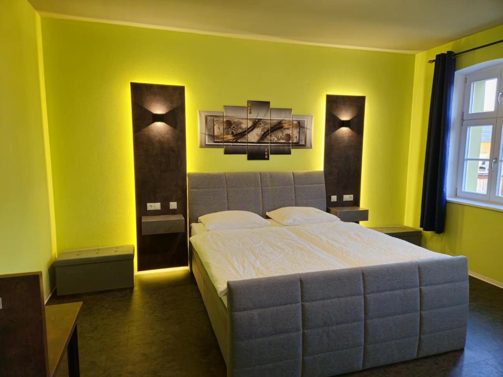 a bedroom with a large bed with yellow walls at Ferienwohnung Gebauer in Görlitz