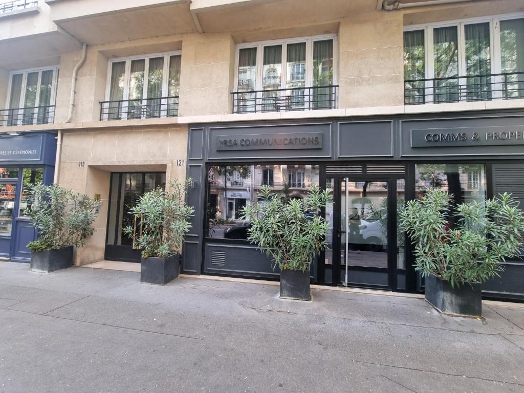 un front de magasin avec des plantes en pot devant lui dans l'établissement Très beau studio Paris 15, proche des commerces et de la tour Eiffel, à Paris