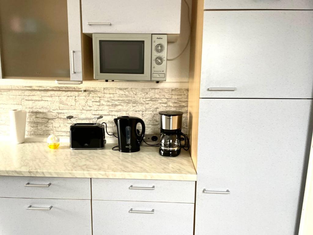 a kitchen with a microwave and a coffee maker on a counter at Ferienwohnung für 5 Personen, gemütlich und möbliert in Stein
