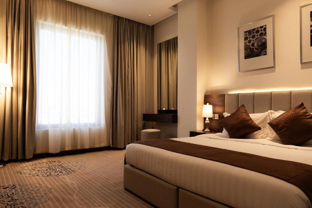 Habitación de hotel con cama y ventana en Dream Residence Khobar, en Al Khobar