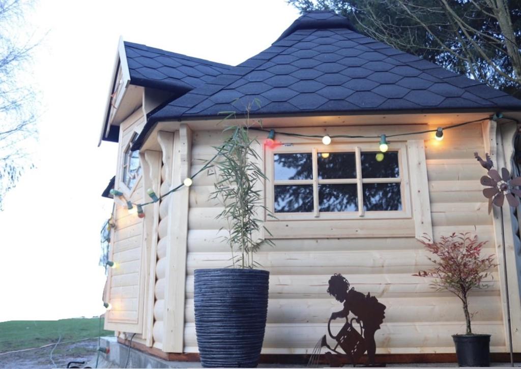 een klein hondenhok met een potplant erin bij Cabane dans un jardin arboré in LʼAbsie