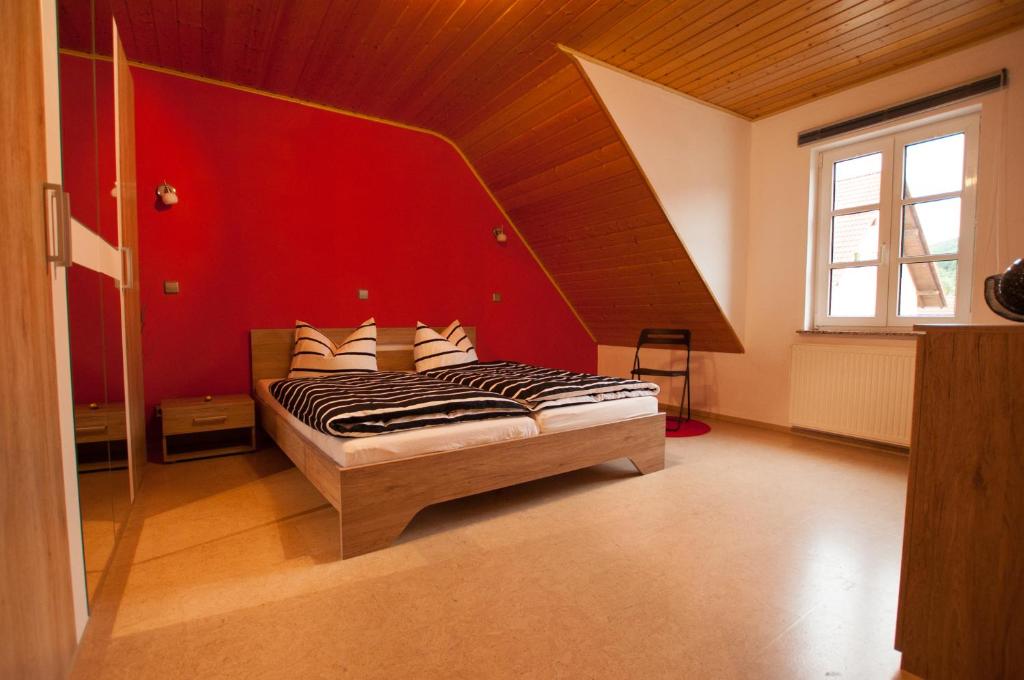 ein Schlafzimmer mit einem Bett mit einer roten Wand in der Unterkunft Business Apartment in Glanbrücken