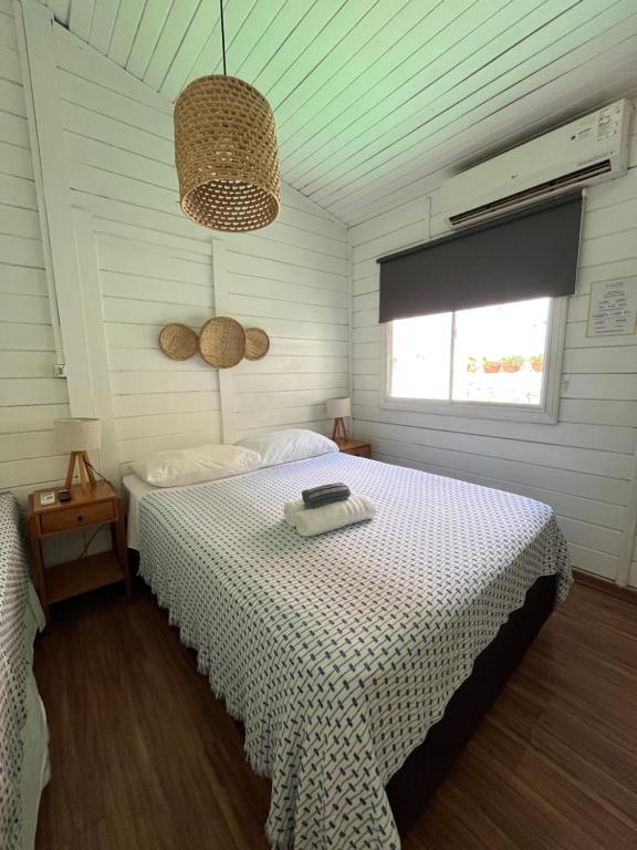1 dormitorio con cama, ventana y techo en Maré suites, en Fernando de Noronha