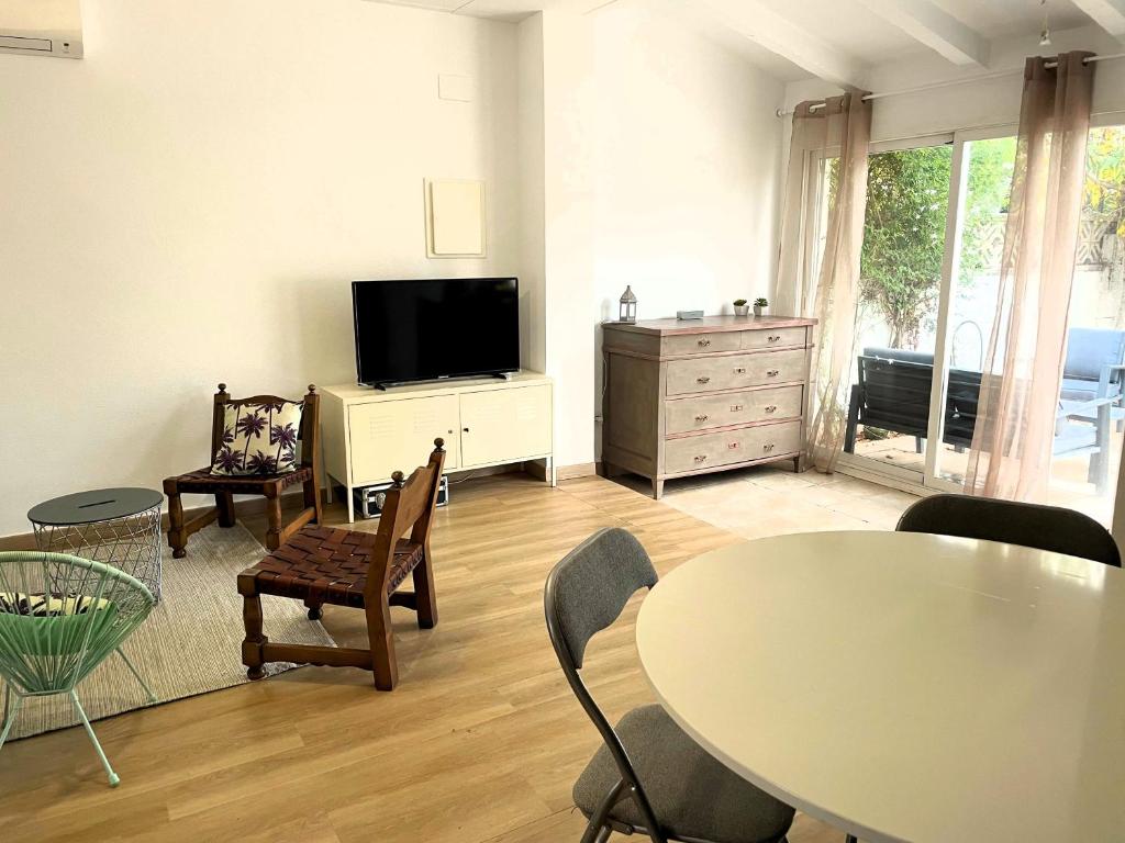 uma sala de estar com uma mesa e uma televisão em GLOBAL IMMO 5058 CASA PARADIS em Roses