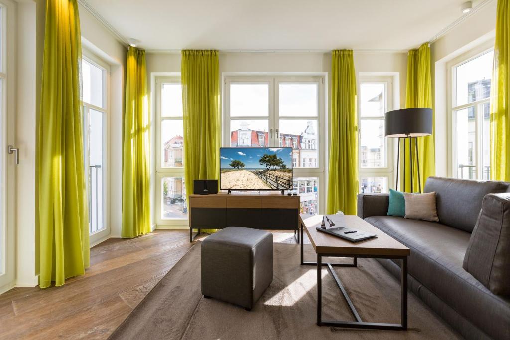 uma sala de estar com cortinas amarelas e um sofá e um piano em Beachhouse Bansin App 14 em Bansin