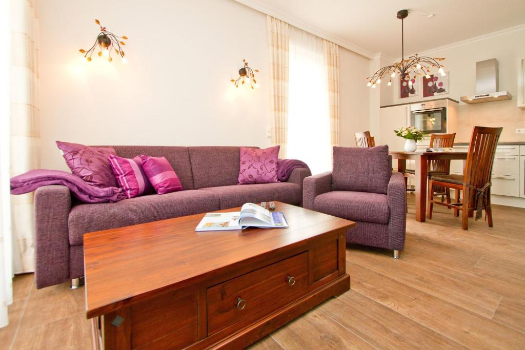 ein Wohnzimmer mit einem Sofa und einem Tisch in der Unterkunft Dünenpalais, App. 06 in Ahlbeck