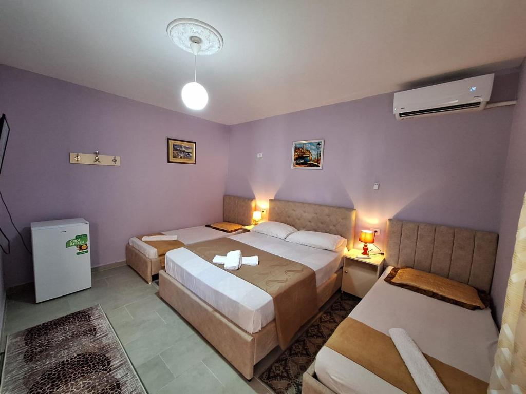 two beds in a room with purple walls at Hotel Sabi in Veminasi