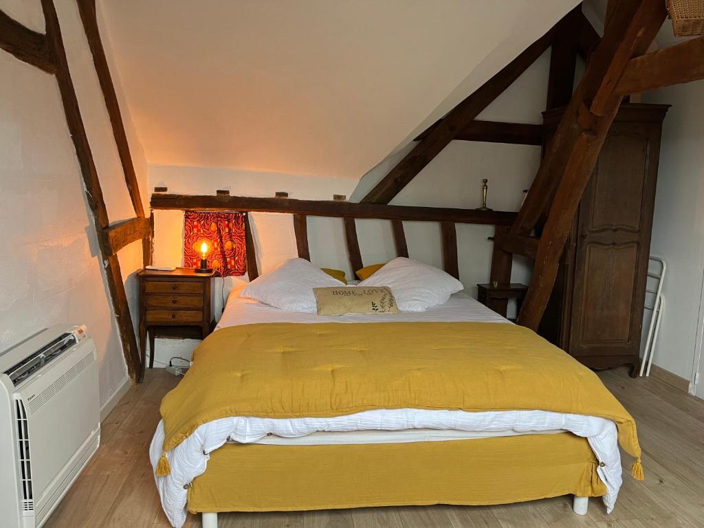 Plachy-BuyonにあるLa Fermette Picardeのベッドルーム1室(黄色い毛布付きのベッド1台付)