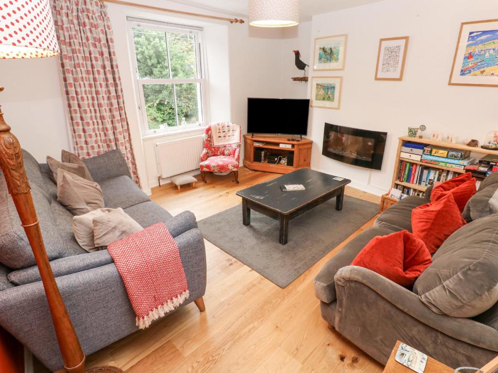 a living room with two couches and a tv at Dolphin Cottage in Falmouth