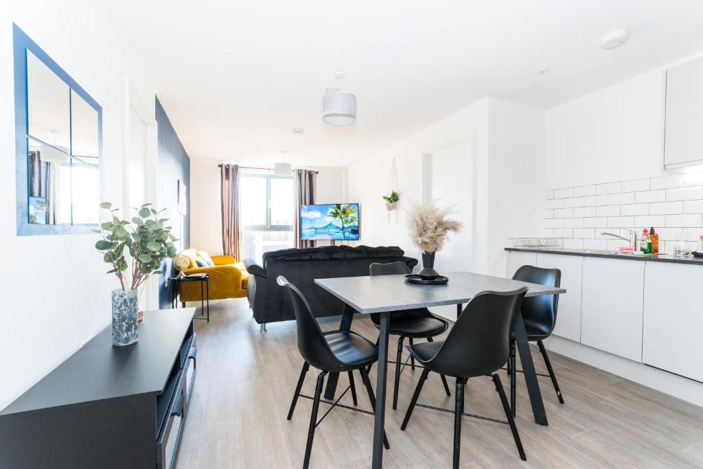 uma cozinha e sala de estar com mesa e cadeiras em Morden 2 Bed Apartment - Manchester Old Trafford em Manchester