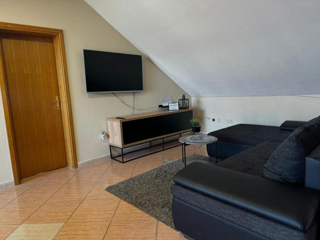 Televízia a/alebo spoločenská miestnosť v ubytovaní Apartmani Sunset