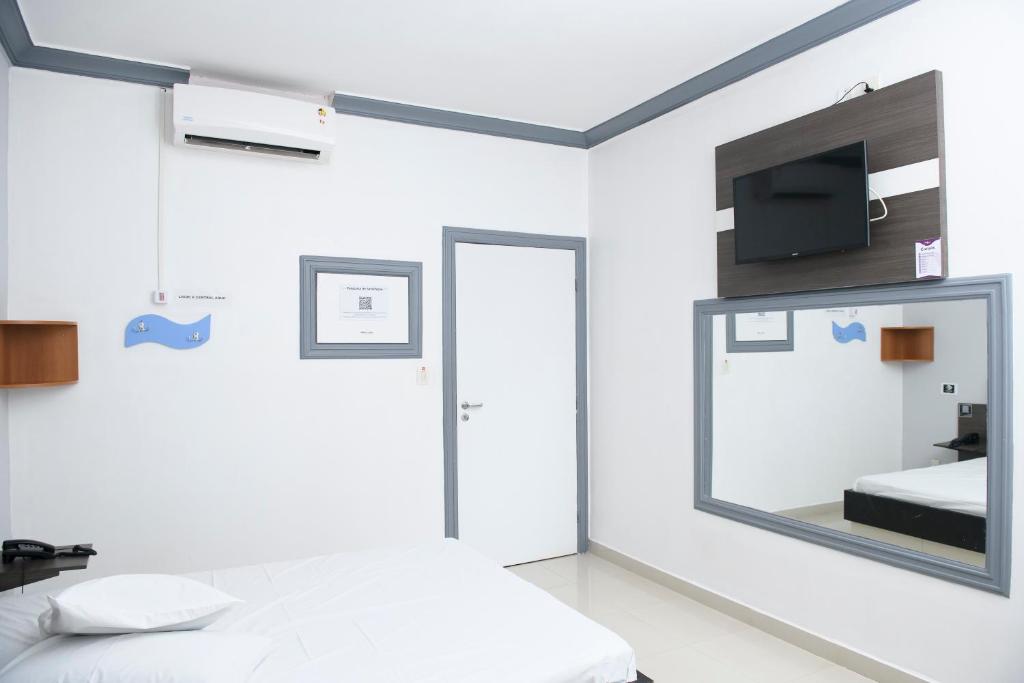 1 dormitorio con 1 cama y TV en la pared en Nidore Motel en Boa Vista