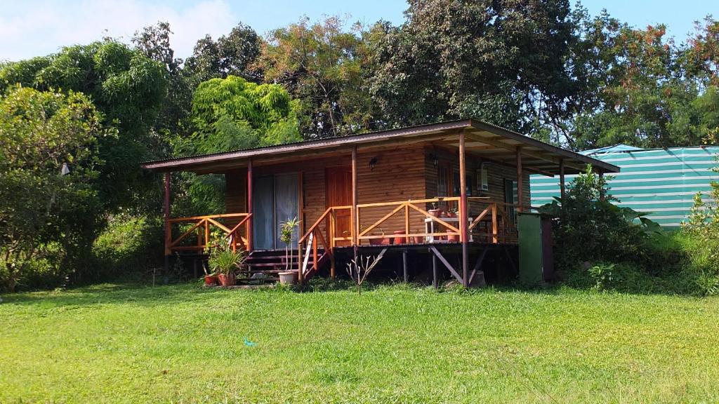 a wooden cabin with a porch in a field at Cabañas Akiko in Hanga Roa