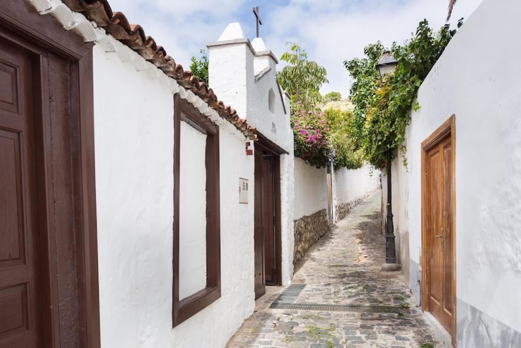 an alley with white houses and a door at Casa Aregume in Los Silos