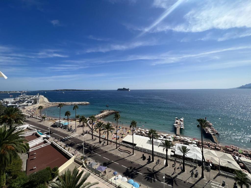 une vue sur une plage avec des palmiers et l'océan dans l'établissement Sea View Bellamare next Palais Festival, à Cannes