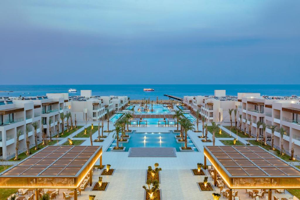 an aerial view of a resort with a pool and the ocean at Jaz Amara in Marsa Alam City