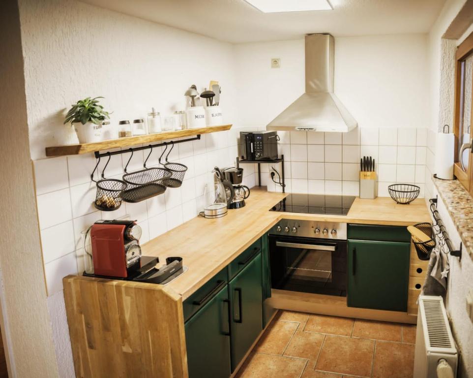 a kitchen with green cabinets and a stove top oven at Ferienwohnung am Berg Oybin in Oybin