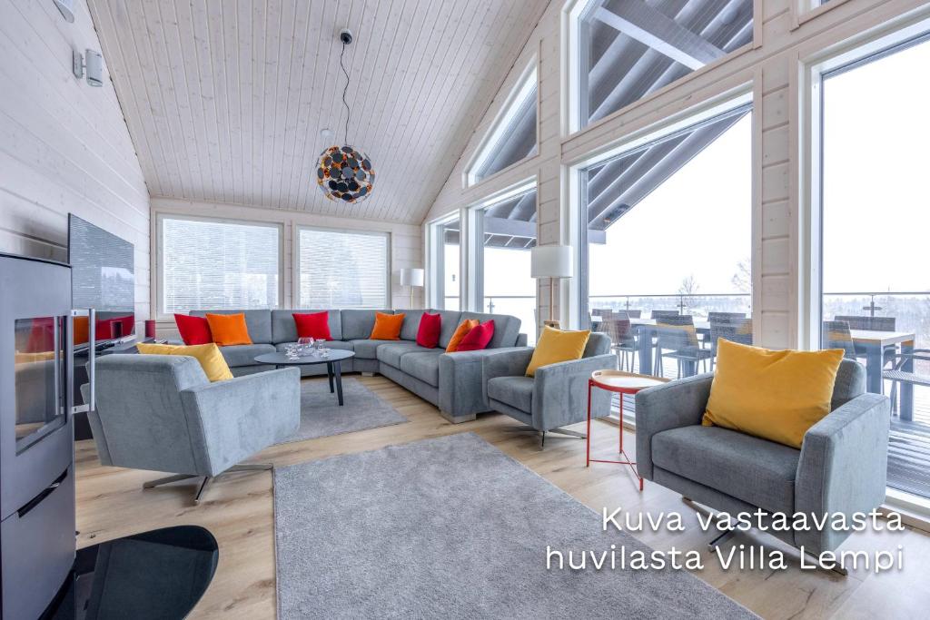 Luksushuvila Villa Helmi في يامسا: غرفة معيشة مع كنب وطاولات ونوافذ