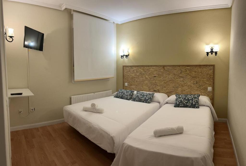 1 dormitorio con 2 camas y toallas. en HOSTAL-RESTAURANTE POSADA DEL DUQUE, en Villalbilla de Burgos