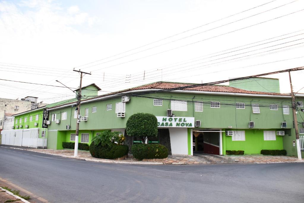 een groen gebouw aan de straatkant bij Hotel Casa Nova in Várzea Grande