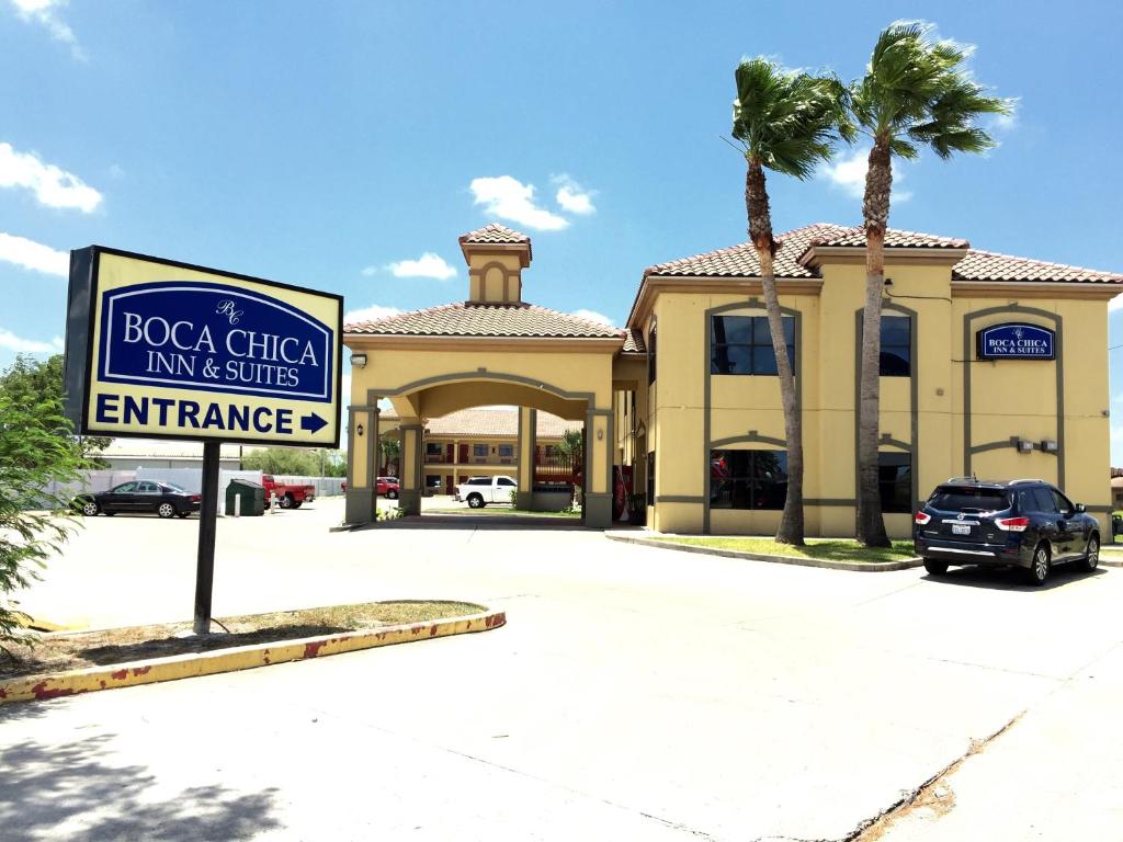 a sign in front of a shopping center with a building at Boca Chica Inn and Suites in Brownsville