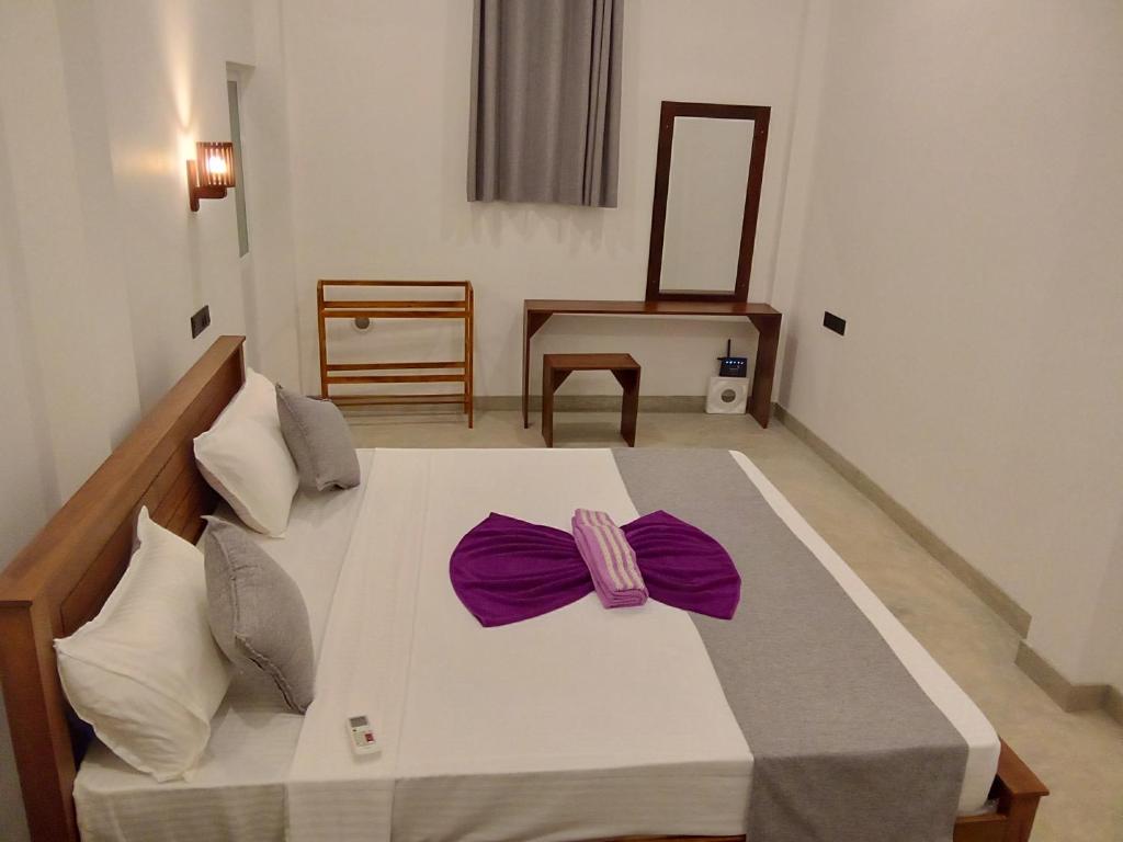 1 dormitorio con 1 cama blanca grande con arcos morados en LaRoy Mirissa- Introducing Smart Room en Mirissa