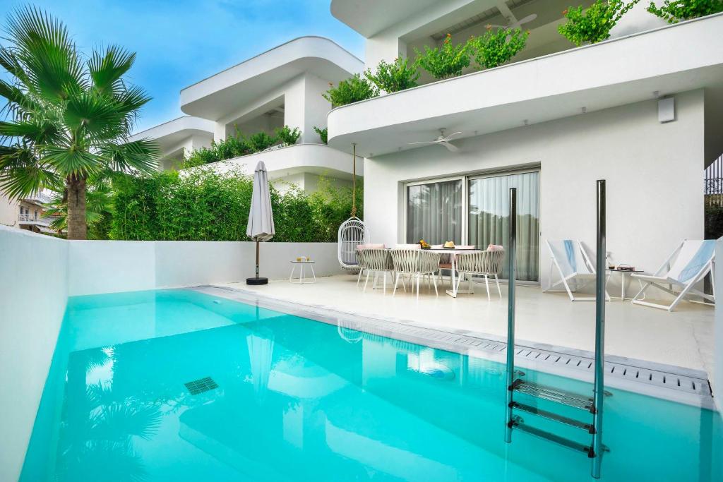 a villa with a swimming pool and a house at Cocoοns Suites & Villas Fourka in Fourka