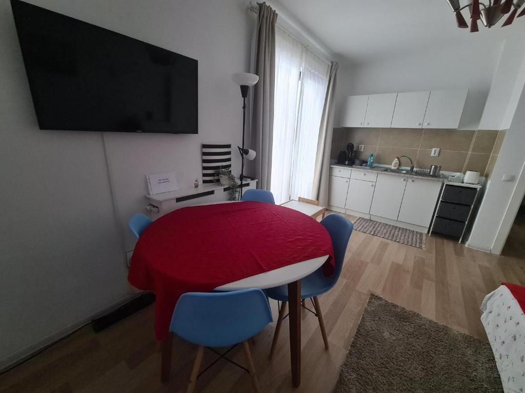 a room with a table and chairs and a kitchen at City view apartment in Bragadiru