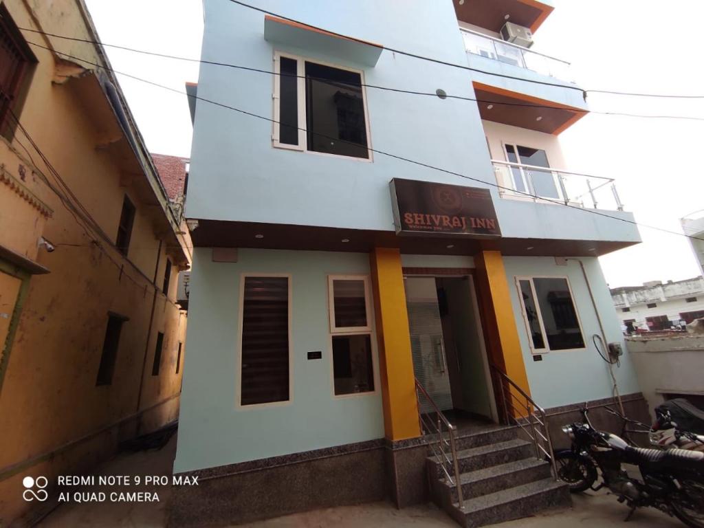 a white building with a staircase in front of it at Shivraj Inn in Varanasi