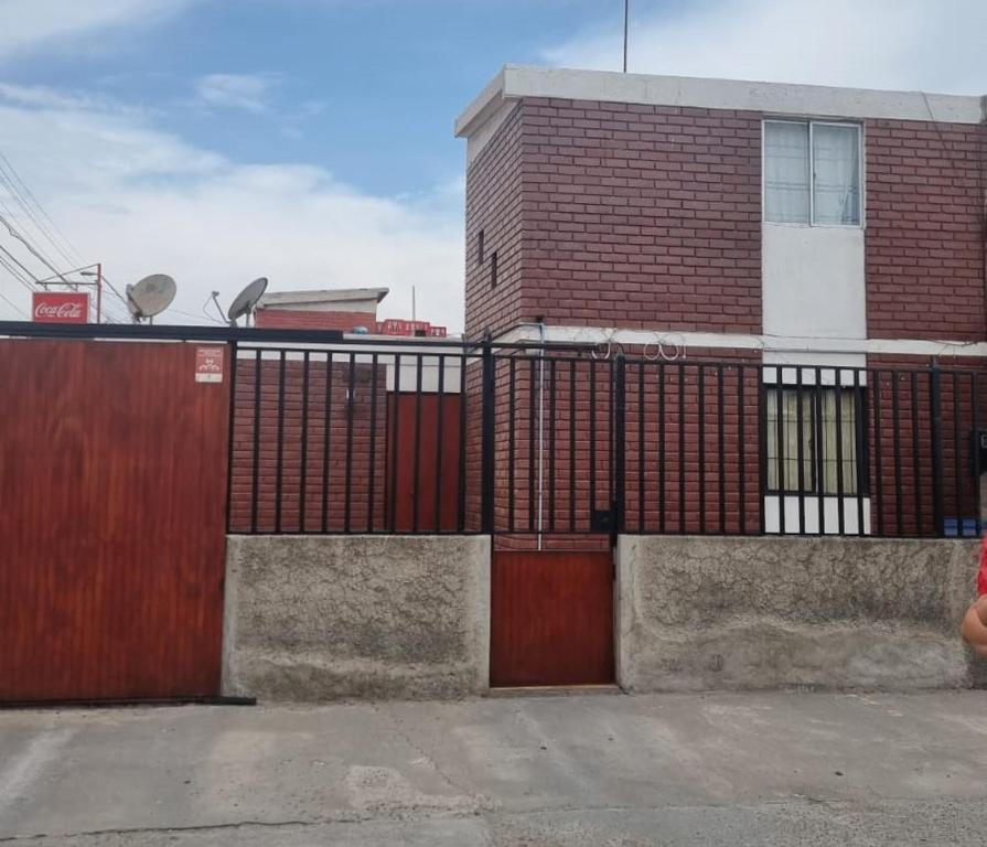 ein Backsteingebäude mit einem Tor und einem Gebäude in der Unterkunft Departamento casa en arica in Arica