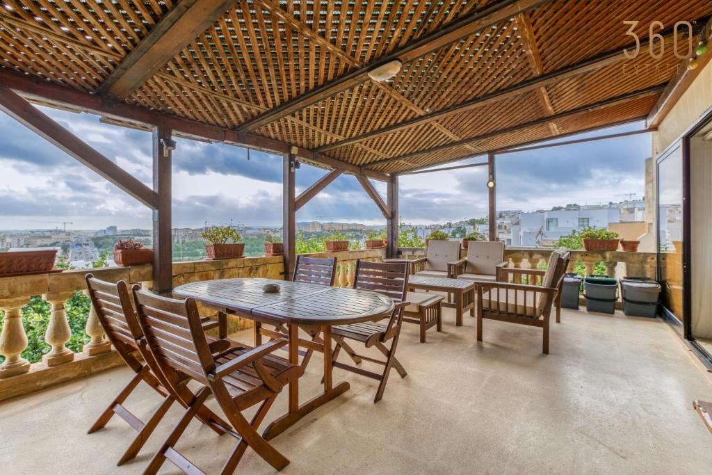 jadalnia ze stołem, krzesłami i oknami w obiekcie Stunning 4BR Villa with Huge Terrace in Kappara by 360 Estates w Gżirze