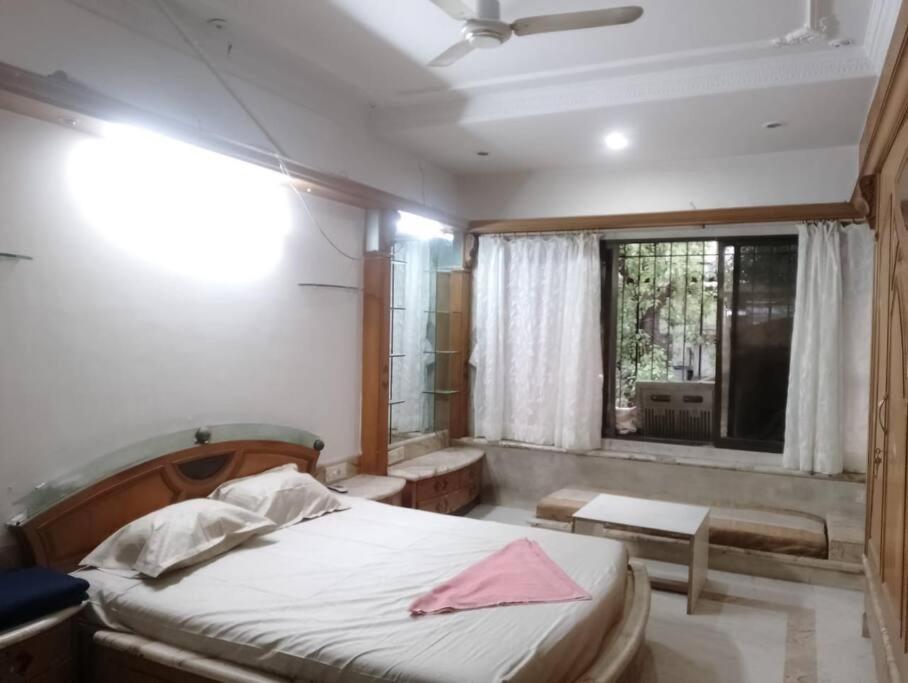 a bedroom with a bed and a window at Luxury Studio with bathtub in Mumbai