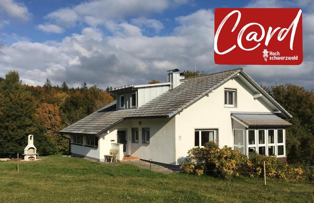 une maison blanche avec un panneau de cocacola devant elle dans l'établissement Haus Findling, 10 Personen, Schluchsee, Hochschwarzwaldkarte, à Schluchsee