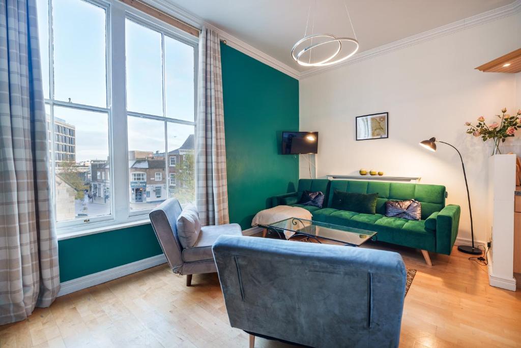 uma sala de estar com um sofá verde e uma cadeira em York Suite on the historic Shambles, sleeps 6 em York