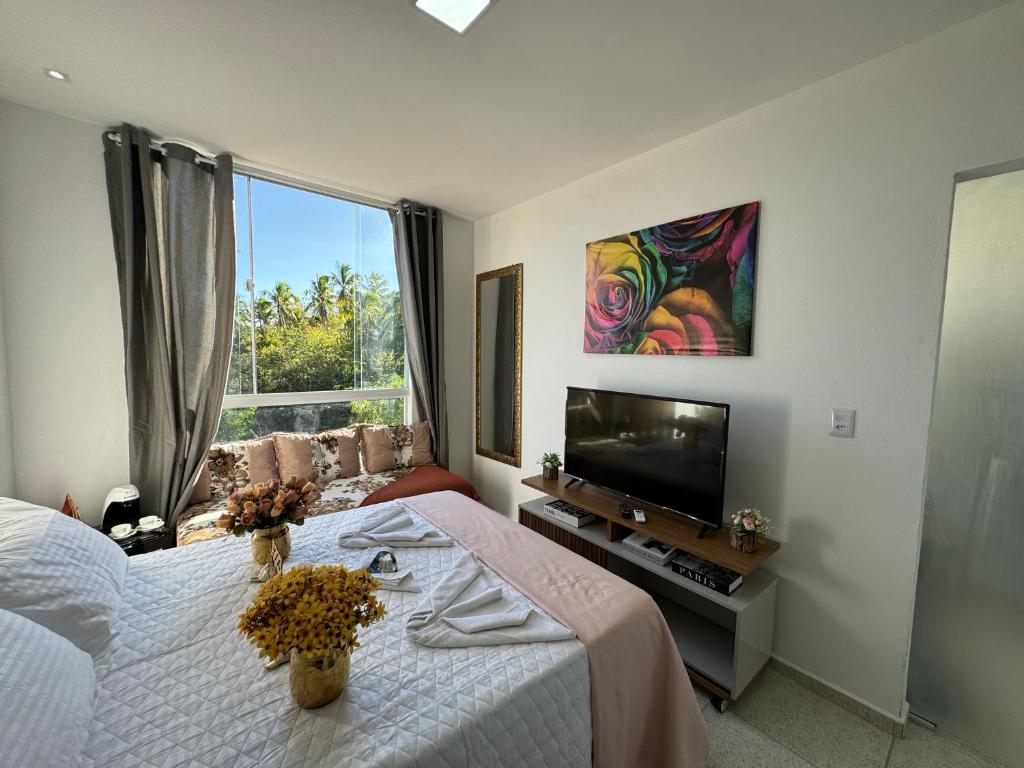 a bedroom with a bed and a flat screen tv at Pousada Hércules Beach Paradise in Maragogi