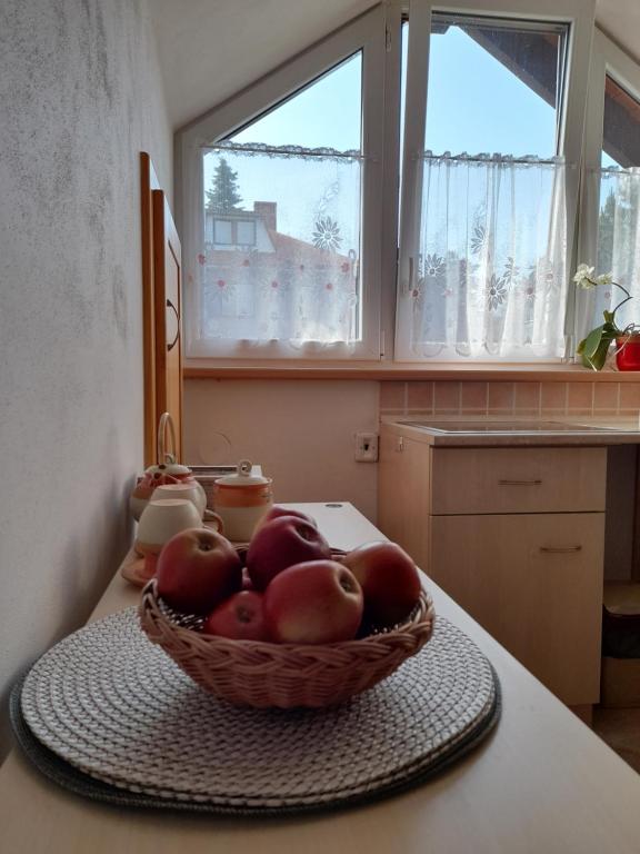 um cesto de maçãs numa mesa numa cozinha em Apartmán u potoka em Nové Město na Moravě