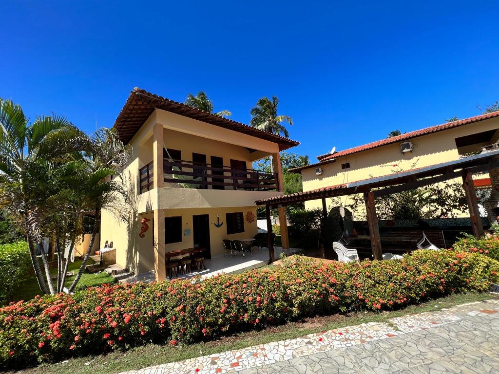 ein Haus mit einer Terrasse und einer Palme in der Unterkunft Casa em Antunes Maragogi Condomínio Beira Mar in Maragogi