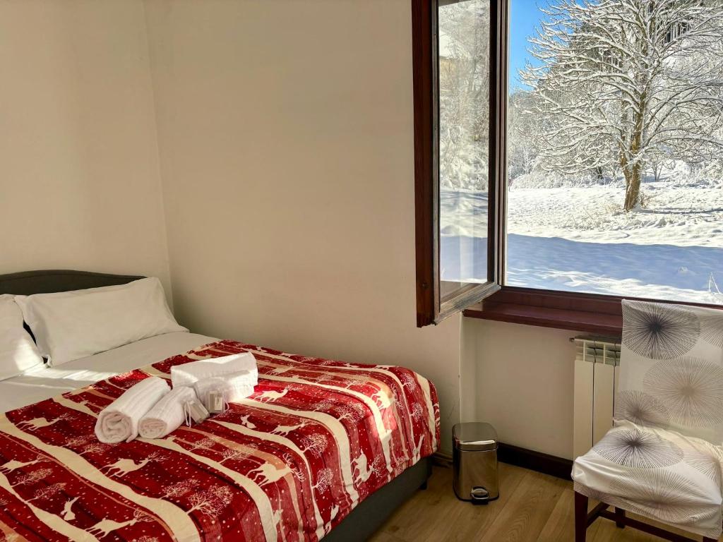 a bedroom with a bed and a window with snow at Lussuosa Suite in Montagna con WIFi e Netflix in Tarvisio